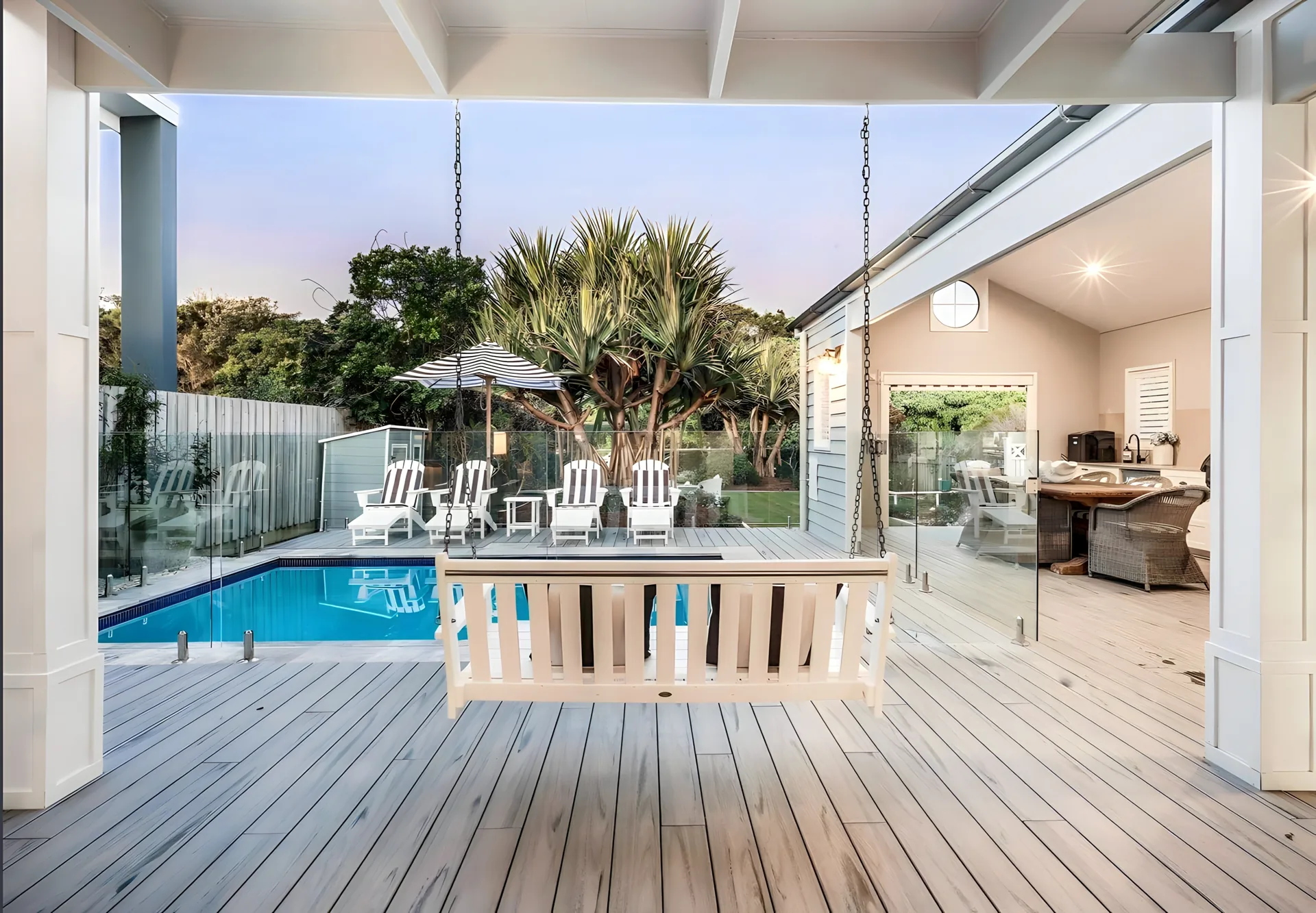 A covered veranda with a swing seat opening onto a garden